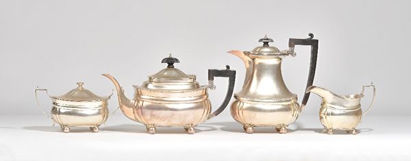 A silver four piece tea set, comprising; a teapot and a hot water jug, having black handles and finials to the hinged lids, a twin handled sugar bowl