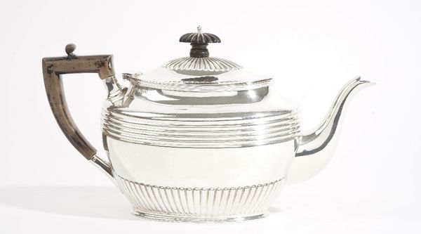 A late Victorian silver teapot, of oval form, with fluted and banded decoration, with an ebonised handle and finial to the hinged lid, Sheffield 1898,