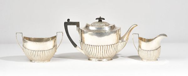 Silver tea wares, comprising; a teapot of oval form, with partly fluted decoration and with black fittings, Sheffield 1902, a twin handled sugar bowl