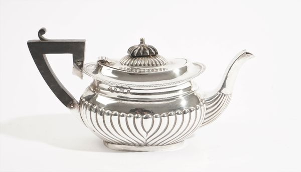 A silver teapot, of oval form, with curved fluted decoration, fitted with a black handle and finial to the hinged lid, Birmingham 1901, gross weight 3