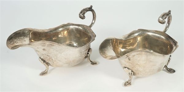 A pair of silver sauceboats, each with a shaped rim, scrolling handle and raised on three feet, Birmingham 1969, combined weight 420 gms, (pair).