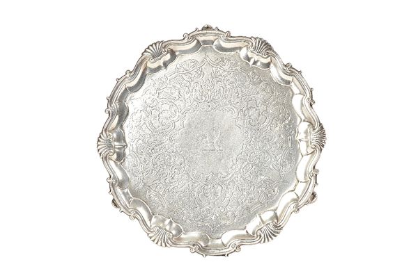 A George II silver salver, of shaped circular form, having a shell and pie-crust rim, with later scroll engraved decoration, lion crest to the centre,