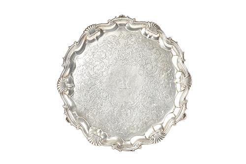 A George II silver salver, of shaped circular form, having a shell and pie-crust rim, with later scroll engraved decoration, lion crest to the centre,