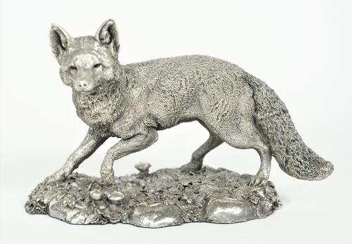 A silver model of a standing fox, raised on a shaped oval rustic base (detailed filled), Birmingham 1996, length 12.5cm x height 9.5cm.