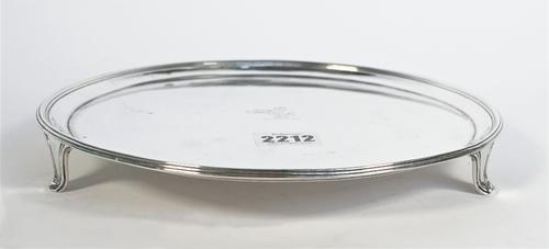 A George III silver salver, of plain circular form, crest engraved to the centre, raised on three tapered feet, London 1790, diameter 23cm, weight 458