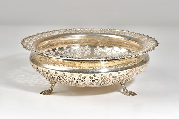 A silver shaped circular bowl, with scroll pierced decoration, within a shaped rim, raised on three feet, diameter 25.5cm, Sheffield 1924, weight 838