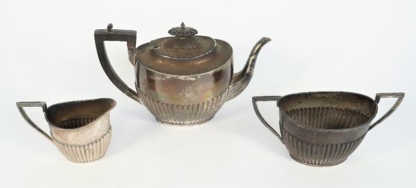 A late Victorian silver three piece tea set, comprising; a teapot with black fittings, a twin handled sugar bowl and a milk jug, each piece of oval fo