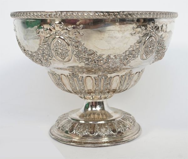 A silver bowl, of circular form, embossed with floral and foliate swags, alternating with oval medallions, having bow surmounts, within a gadrooned ri