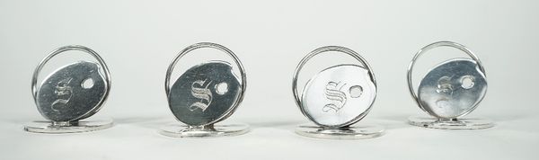 A set of four silver menu holders, formed as artists palettes, each initial engraved and raised on circular disc stands, by Walker & Hall, Birmingham