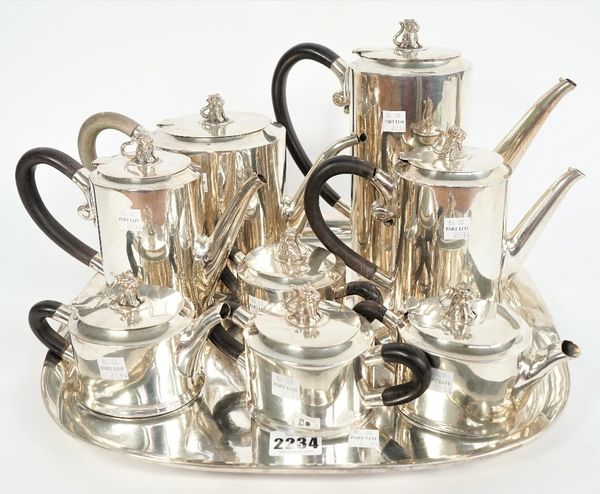 A Mexican nine piece silver tea/coffee service, each of the eight hollow ware pieces of oval form, having black handles and with a seated animal finia