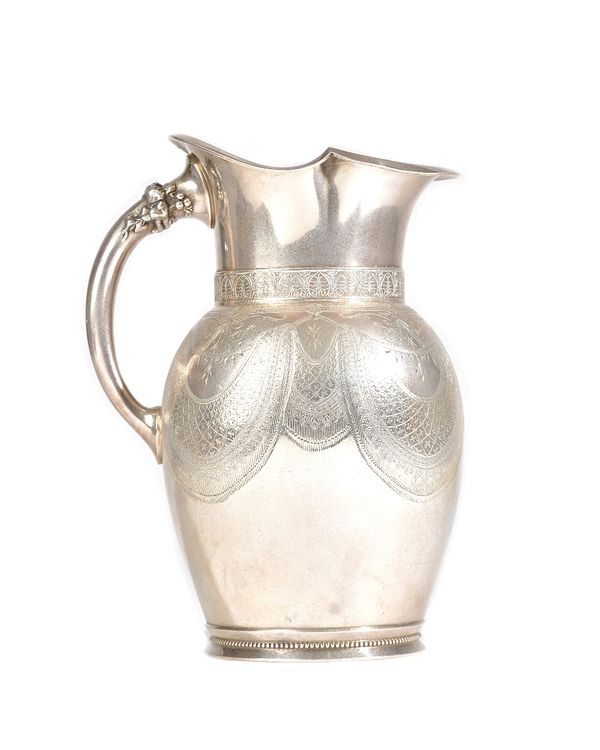 An American silver water jug, the body with engraved decoration, otherwise with a monogram to the front, the handle decorated with a foliate spray wit