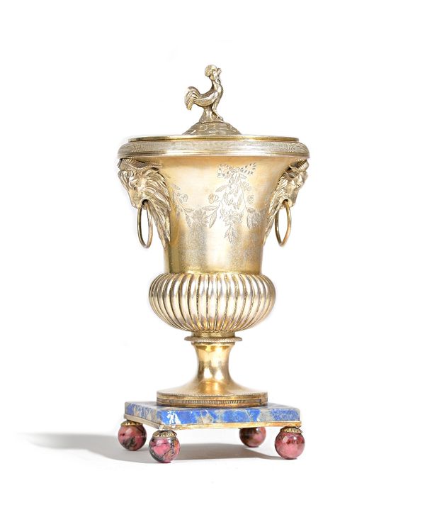 A French Empire silver gilt urn and cover, the body of bulbous form, with fluted decoration, the top with twin goat's mask and ring handles, otherwise