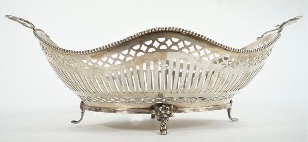 A Dutch twin handled fruit or cake basket, of shaped oval form, having pierced decoration within a beaded rim, the cast scrolling handles having flora