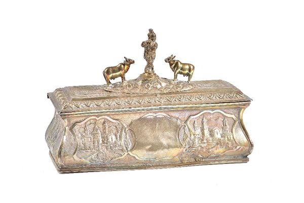 An Asian shaped rectangular hinge lidded box, the cover and the sides embossed and chased with buildings within a floral surround, the hinged lid cent