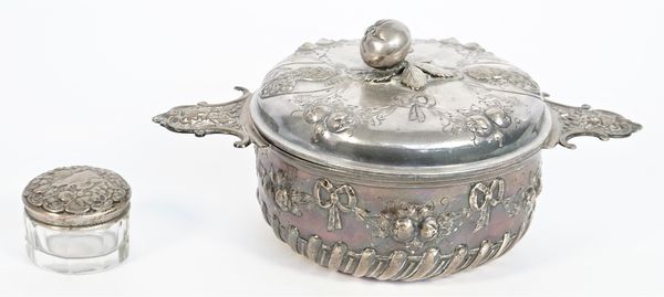 A European twin handled bowl and cover, the body with partly spiral fluted tied bow and pendant swag embossed decoration, the handles cast as masks, t