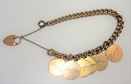 A gold curb link bracelet, with a 9ct gold heart shaped padlock clasp and a gilt metal boltring clasp, the bracelet fitted with six gold disc shaped p