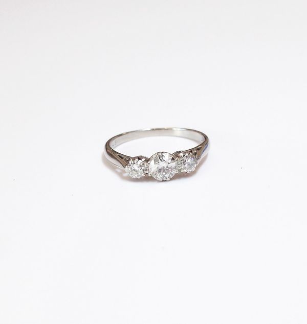 A platinum and diamond set three stone ring, mounted with a row of circular cut diamonds, with the principal diamond mounted at the centre, detailed A