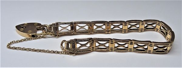 A gold curved bar link gate bracelet, on a gold heart shaped padlock clasp, detailed 15 CT, weight 21.2 gms.