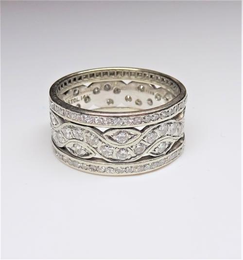 A diamond set wide band full eternity ring, in a pierced openwork design, mounted with circular cut diamonds, detailed Bristol 14 K, ring size T and a