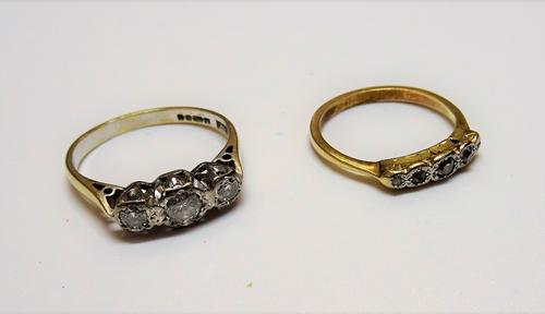 An 18ct gold and diamond set three stone ring, mounted with a row of circular cut diamonds and with the principal diamond mounted to the centre, ring