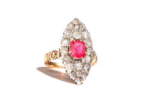 A gold and silver set, diamond and synthetic ruby, marquise shaped cluster ring, claw set with the oval cut synthetic ruby to the centre and otherwise
