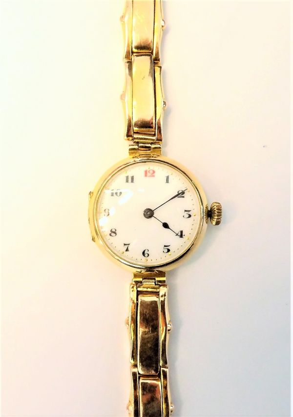 A lady's 9ct gold circular cased wristwatch, with a jewelled movement, the enamelled dial with Arabic numerals, import mark Glasgow 1916, on a gold sp