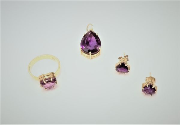 A gold ring, claw set with a curved triangular amethyst, detailed 750, ring size K, a pair of gold and amethyst set single stone earstuds, each claw s