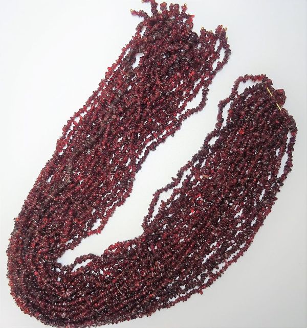 Twelve rows of irregular tumbled garnet beads, (12). 6598