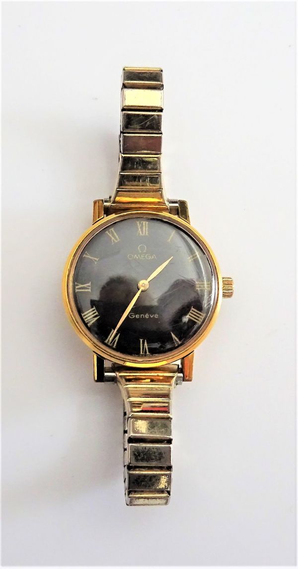 An Omega gilt metal fronted and steel backed lady's wristwatch, the signed black dial with gilt Roman numerals and with gilt hands, Omega logo to the