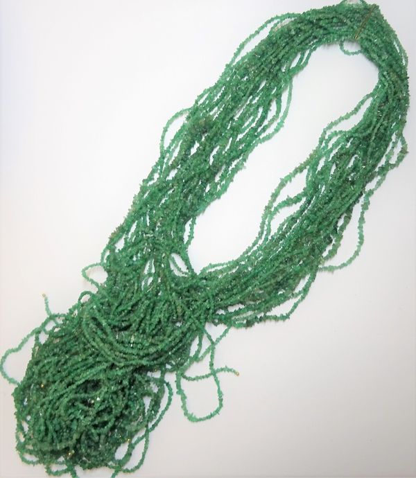 Twenty-one rows of rough emerald beads, (21).  6597