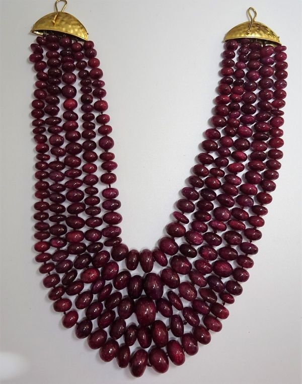 A five row necklace of graduated red stained hardstone beads, on a hook formed clasp, with an abstract finish. 6601