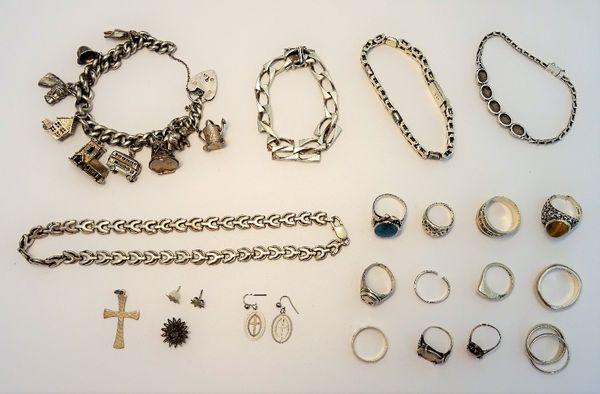 A group of mostly silver jewellery, comprising; a charm bracelet, three further bracelets, a necklace, a pendant cross and twelve rings, a group of co