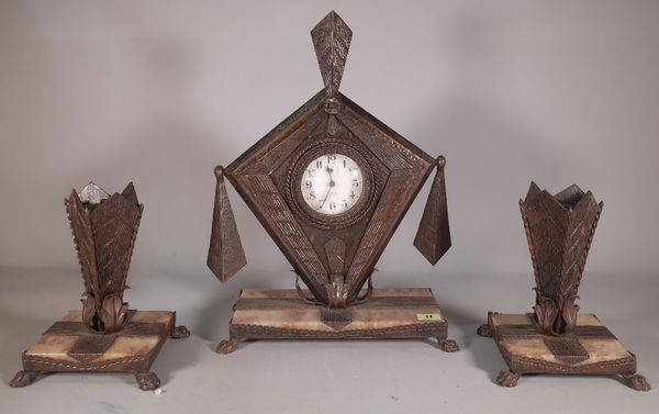 An Art Nouveau composite metal and onyx mantel clock with garnitures, 29cm wide x 45cm high.