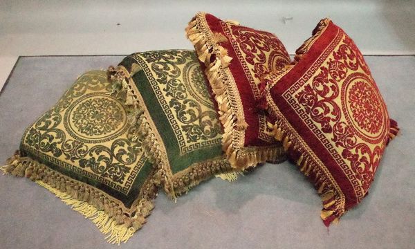 A group of four cushions, comprising; two red and gold and two green and gold, each with tasselled edges and central palmette, 58cm x 58cm, (4).