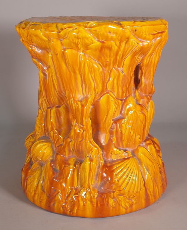 A circular orange ground garden seat, relief moulded with shells and seaweed, 36cm diameter x 32cm high.