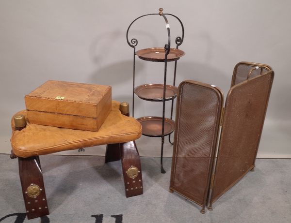 A 20th century hardwood and leather camel saddle, 56cm wide, a wrought iron and copper three tier cake stand, 108cm high and a walnut writting slope w