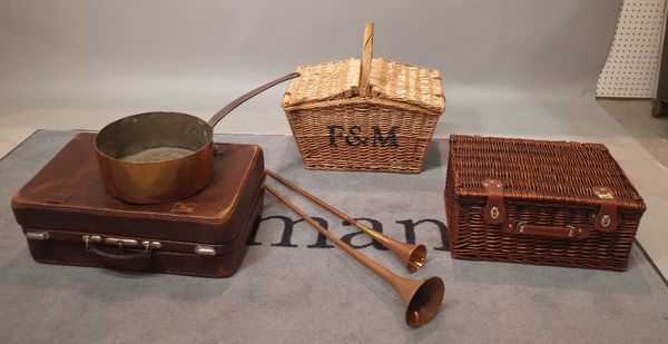 A mid-20th century brown leather suitcase, two long copper hunting horns, two wicker hampers and a copper cooking pan, (6).