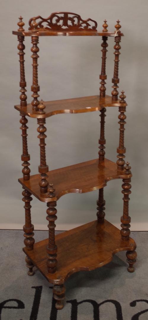 A Victorian walnut four tier serpentine what-not on turned supports, 50cm wide x 128cm high.