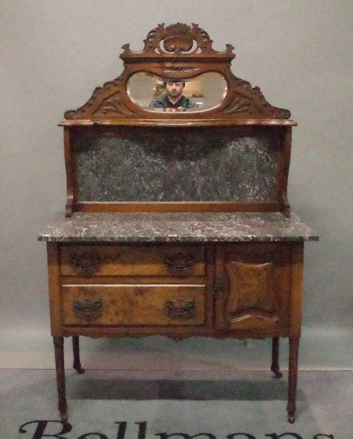 An Edwardian walnut and marble topped sideboard with mirrored back on turned supports, 101cm wide x 165cm high.