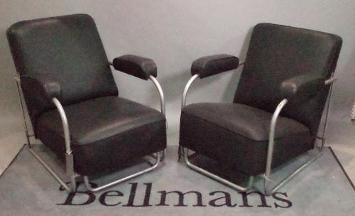 A pair of mid-20th century leather upholstered low open armchairs on chrome tubular supports, 69cm wide x 75cm high.