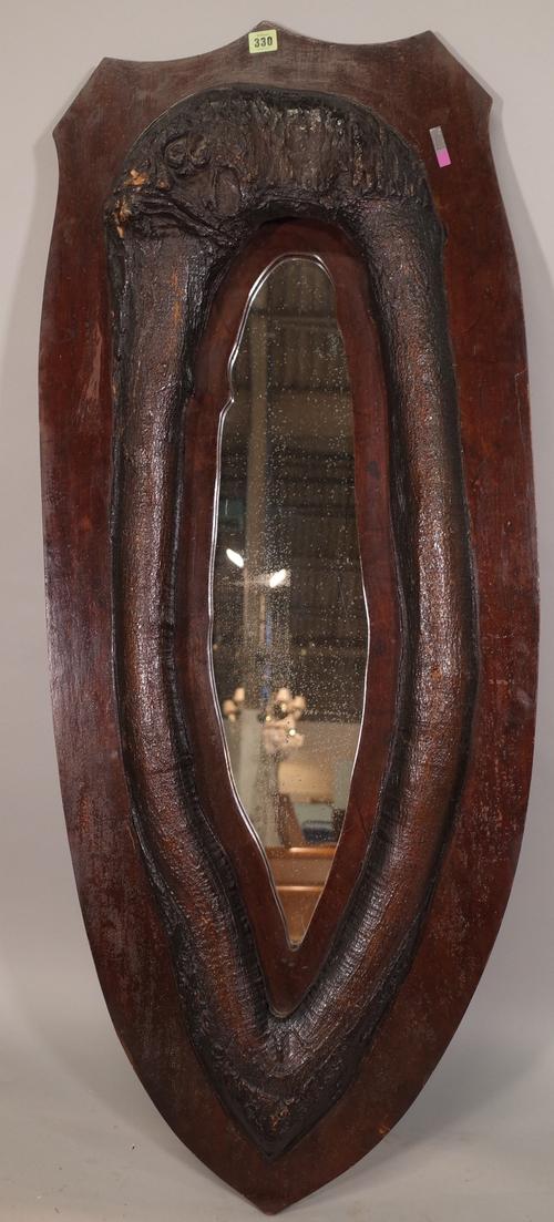 An early 20th century oak wall mirror formed from a tree knot, 51cm wide x 138cm high.