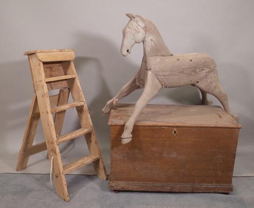 An early 20th century grey painted rocking horse, 96cm wide x 47cm high, a pine step ladder, 81cm high, a early 20th century stained pine trunk, 68cm