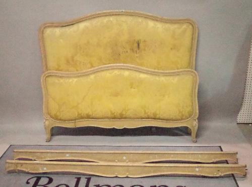 An early 20th century French cream painted  double bed with arch headboard and green foliate upholstery, 140cm wide x 122cm high.