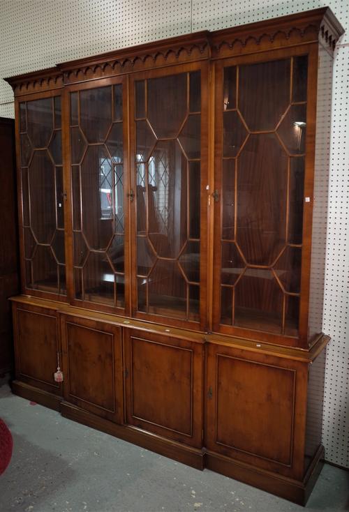 A George III style yew wood breakfront bookcase cabinet with astragal glazed doors on plinth base, 205cm wide x 215cm high.