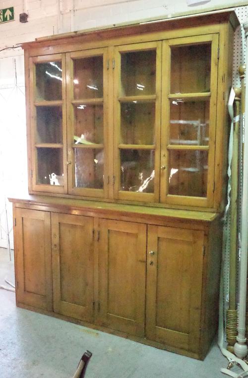 An early 20th century pine dresser with glazed four door top over cupboard base, 181cm wide x 257cm high.
