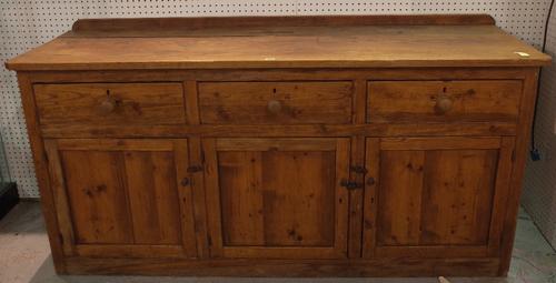 An early 20th century pitch pine dresser base with three drawers over cupboards, 183cm wide x 91cm high.