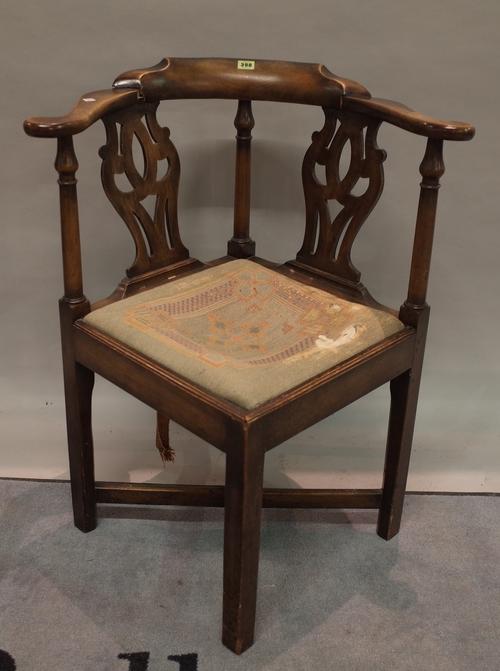 A George III mahogany corner open armchair on block supports united by 'X' frame stretcher, 70cm wide x 86cm high.