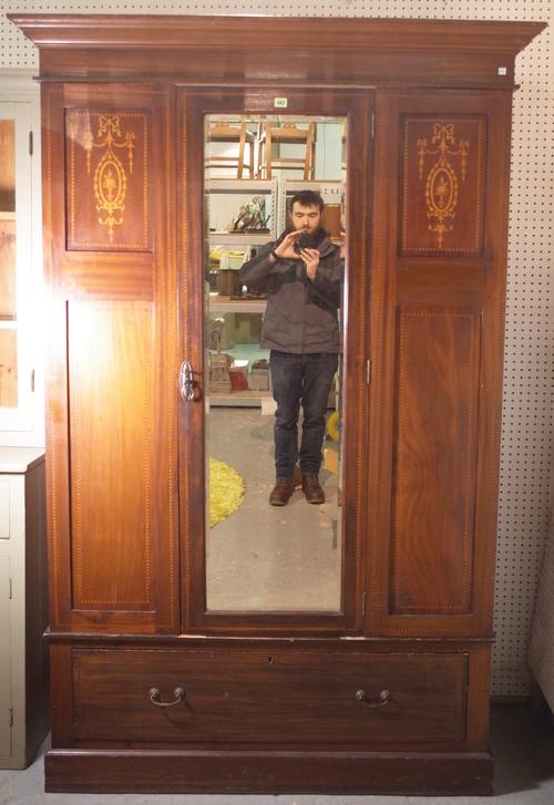 An Edwardian inlaid mahogany single wardrobe with central mirrored door over single drawer base, 126cm wide x 200cm high.