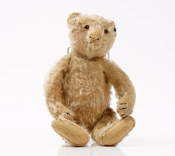 An early 20th century Steiff blonde mohair teddy bear, with jointed arms and legs and button to the right ear, 29cm high.