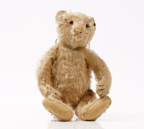 An early 20th century Steiff blonde mohair teddy bear, with jointed arms and legs and button to the right ear, 29cm high.